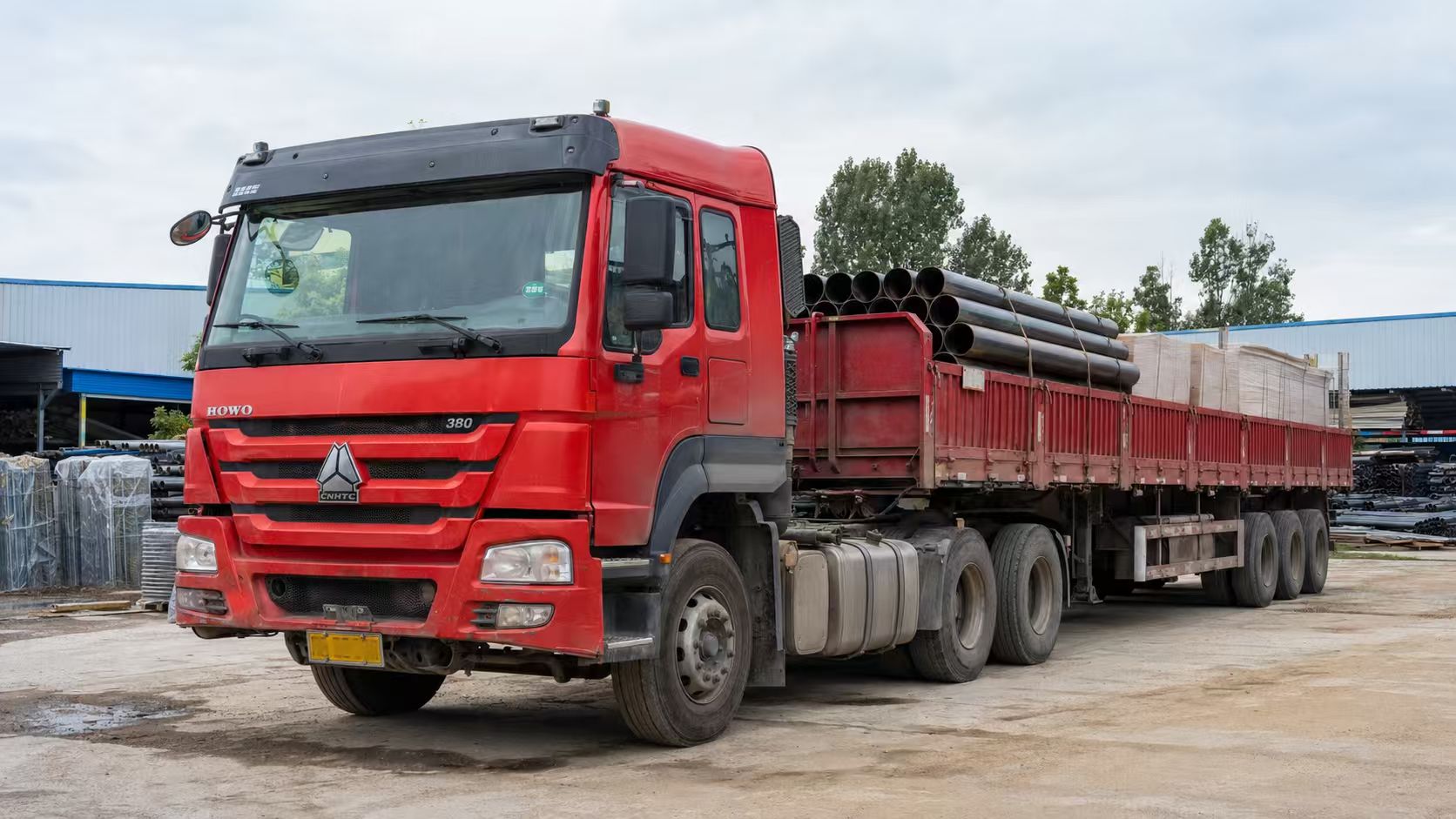 HOWO tractor truck matched with a side wall semi trailer for pipe transport