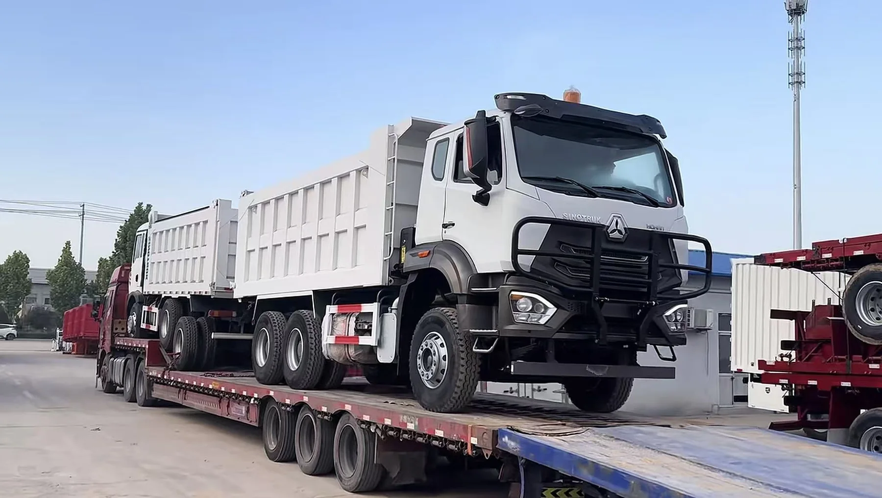White dump truck secured on a flatbed trailer